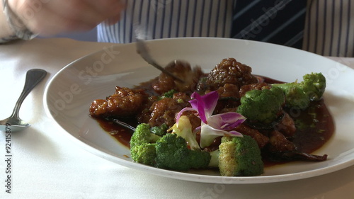 Man eating beef and broccoli dish  photo