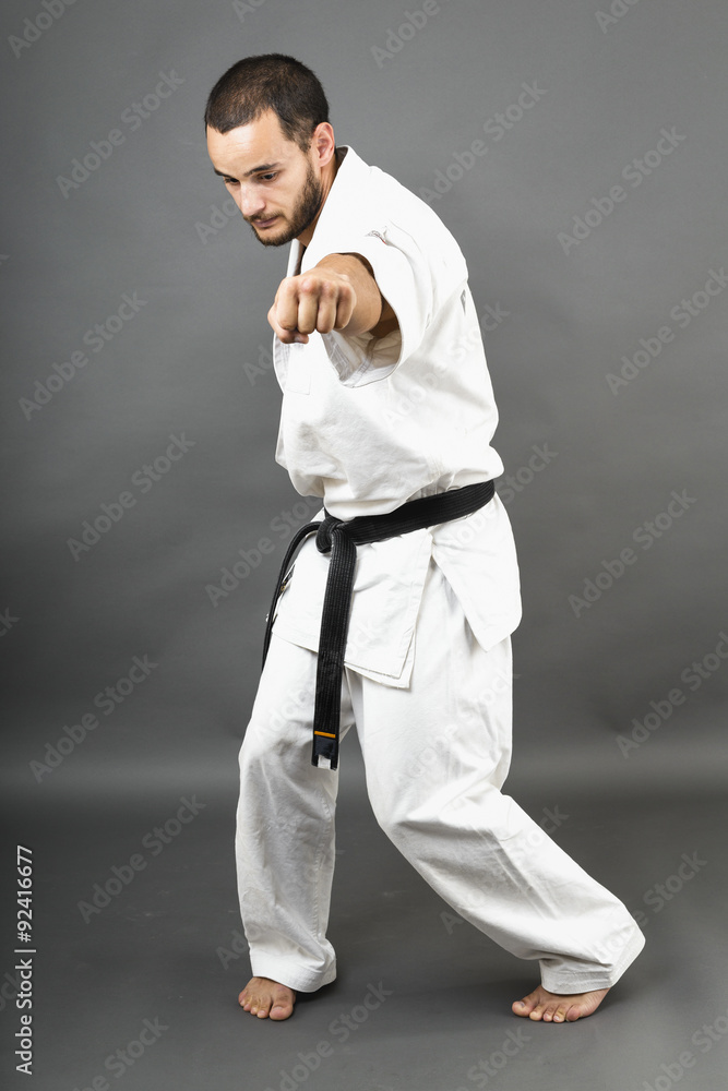 Full length portrait of young man in white kimono and black belt Full length portrait of young man in white kimono and black belt