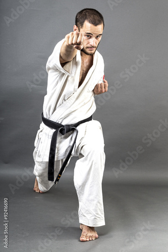Full length portrait of young man in white kimono and black belt
