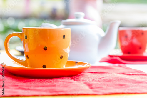 two bright tea cups set for breakfast in outdoor cafe photo