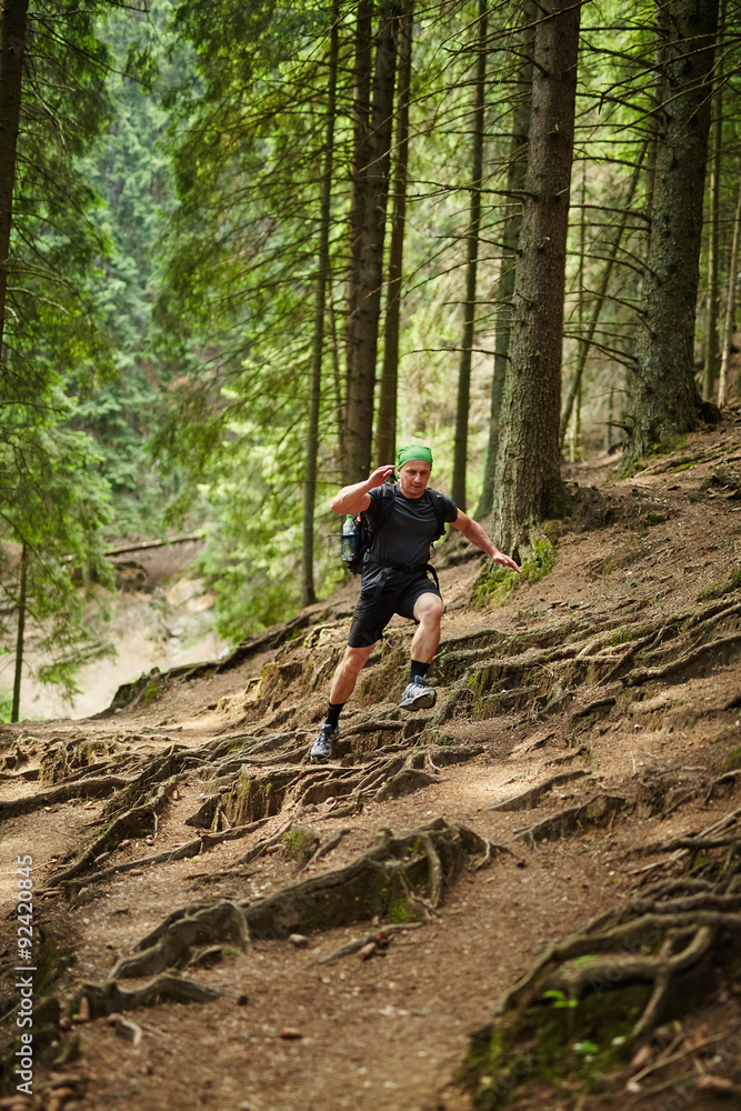 Naklejka premium Man doing trail running in the forest