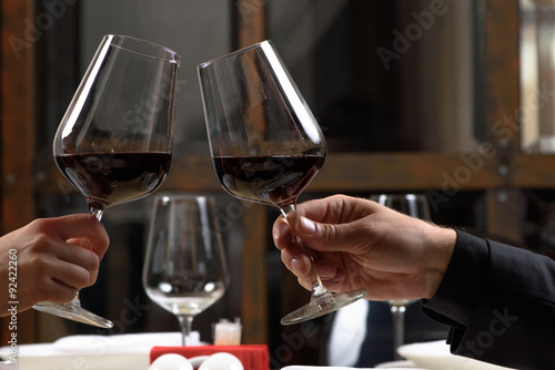 Couple drinking red wine in restaurant. Close-up hands with © chettythomas