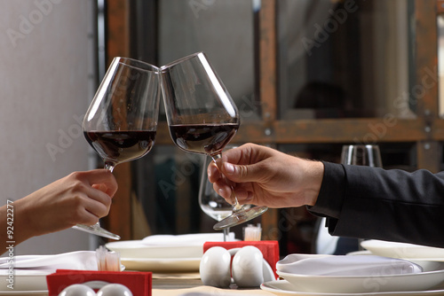 Couple drinking red wine in restaurant. Close-up hands with