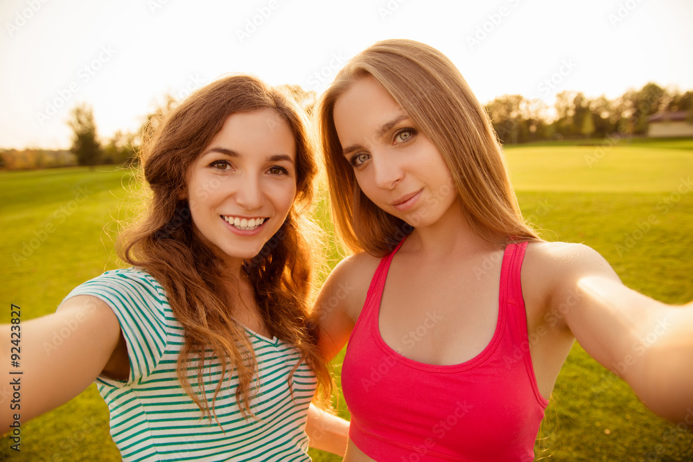Two young sexy girls making selfie photo in the park Two young sexy girls making selfie photo in the park