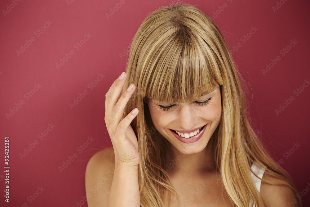 Laughing young blond woman in red studio Laughing young blond woman in red studio