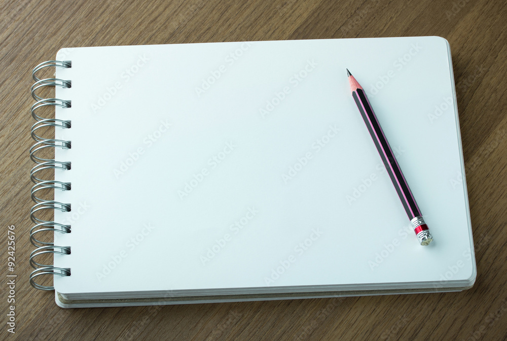 blank spiral notebook and pencil on dark wood background blank spiral notebook and pencil on dark wood background