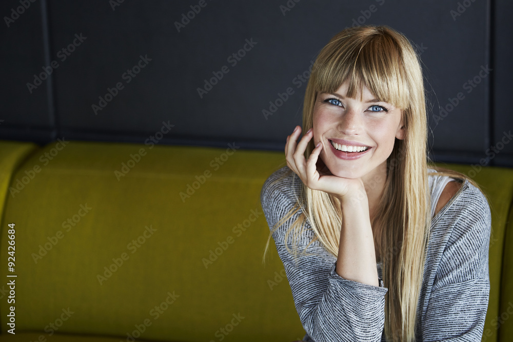 Beautiful young woman smiling on sofa Beautiful young woman smiling on sofa