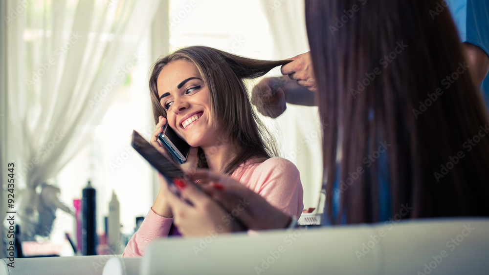 Hairdresser doing haircut for women in hairdressing salon. 