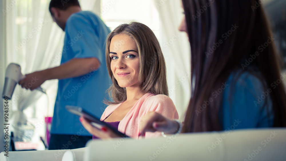 Beautiful woman showing hairstylist on a tablet examples hairstyles. Beautiful woman showing hairstylist on a tablet examples hairstyles.