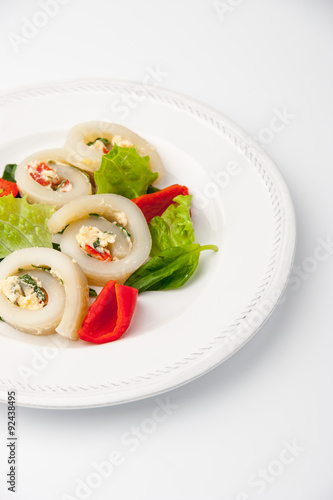 Squid roll with cheese and vegetables on the white background