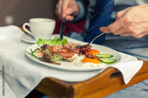 Businessman eating breakfast at home/hotel. Indoor photo.