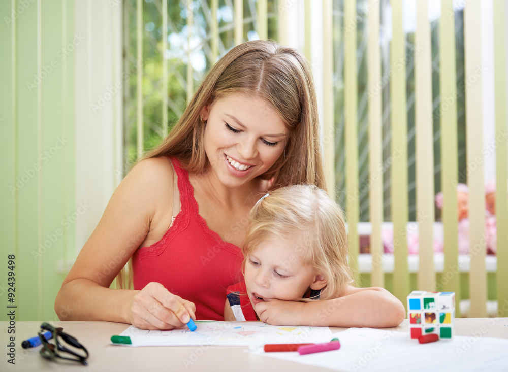 Lesson of art in the kindergarten. Young female kindergartner teaching painting to little girl in classroom. Lesson of art in the kindergarten. Young female kindergartner teaching painting to little girl in classroom.