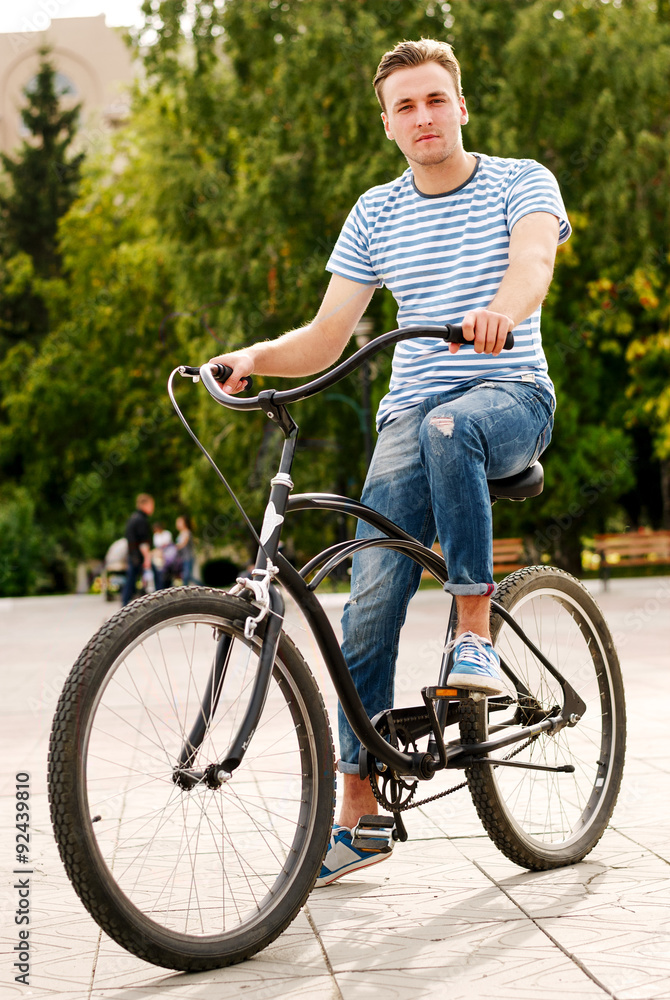 Young man sitting on the bike in the park Young man sitting on the bike in the park