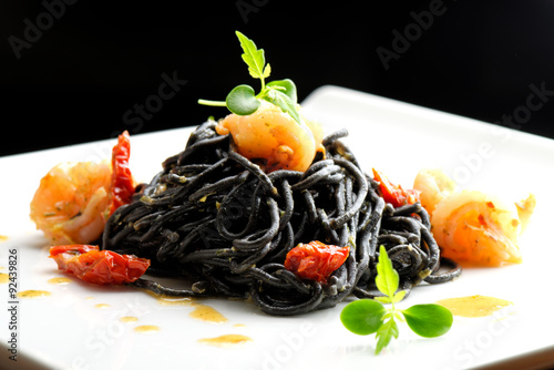 Fényképezés Fine dining, Italian squid ink pasta with shrimp basil selective focus