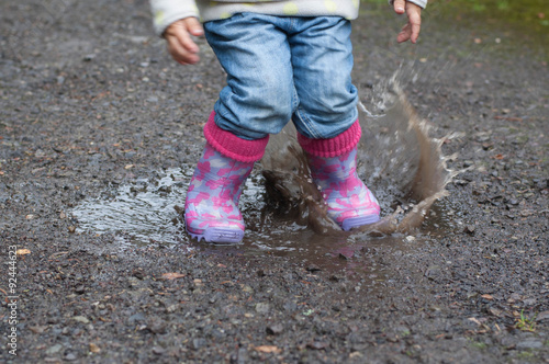 Girl jumps into a puddle