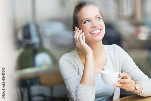 Woman using mobile phone at cafe