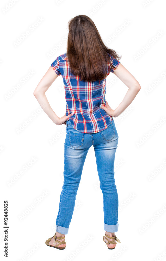 back view of standing young beautiful woman. girl watching. Rear view people collection. A young girl in a checkered blue shirt is resting in the palm of her waist. back view of standing young beautiful woman. girl watching. Rear view people collection. A young girl in a checkered blue shirt is resting in the palm of her waist.
