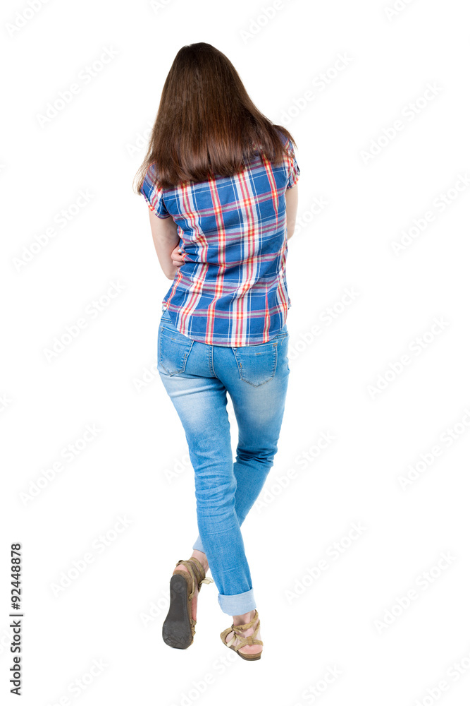 back view of standing young beautiful woman. girl watching. Rear view people collection. A young girl in a checkered blue with red stripes is bent right leg. back view of standing young beautiful woman. girl watching. Rear view people collection. A young girl in a checkered blue with red stripes is bent right leg.
