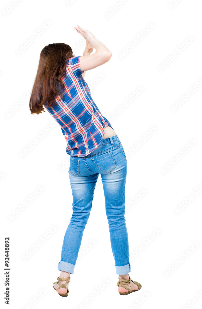 back view of woman protects hands from what is falling from abo back view of woman protects hands from what is falling from abo