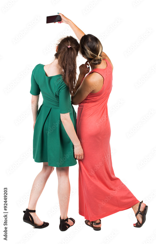 Back view of two young woman photographed on a mobile phone. Back view of two young woman photographed on a mobile phone.