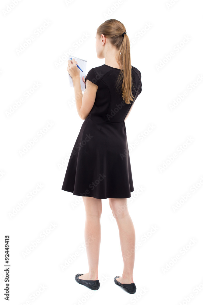 back view of stands woman takes notes in a notebook. back view of stands woman takes notes in a notebook.