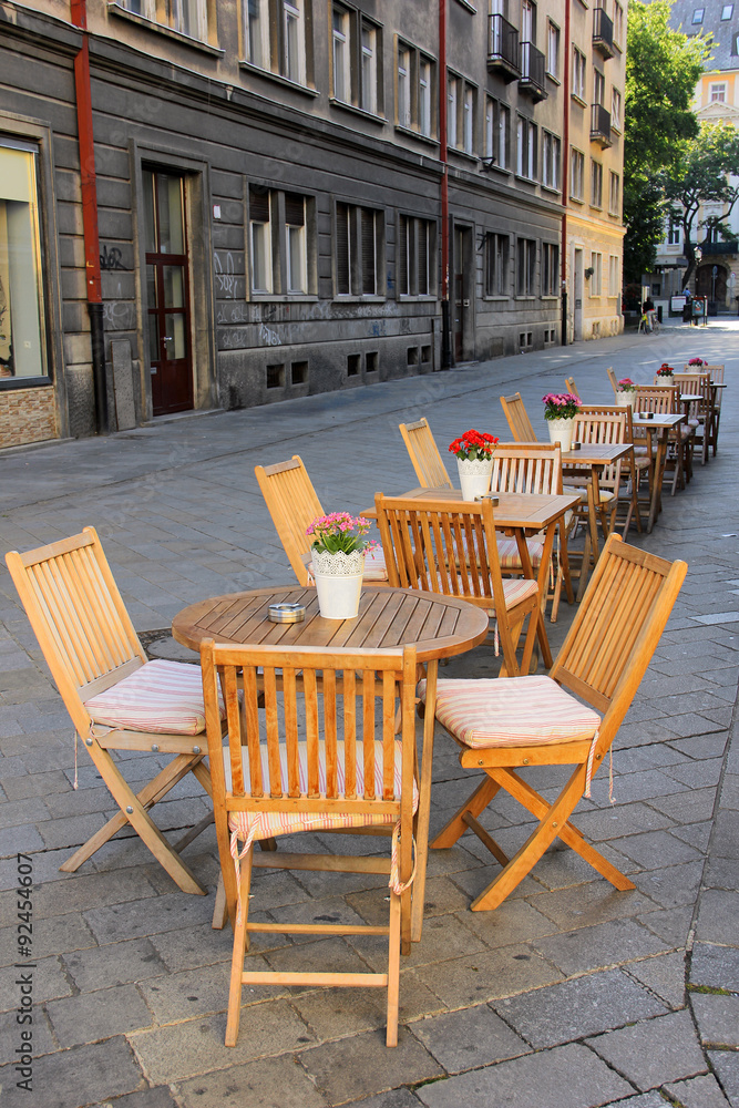 Outdoor coffee shop on the street in Bratislava, Slovakia, with vintage wooden tables and chairs