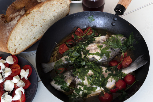 Dorado fish with tomatoes, cooked on a griddle photo