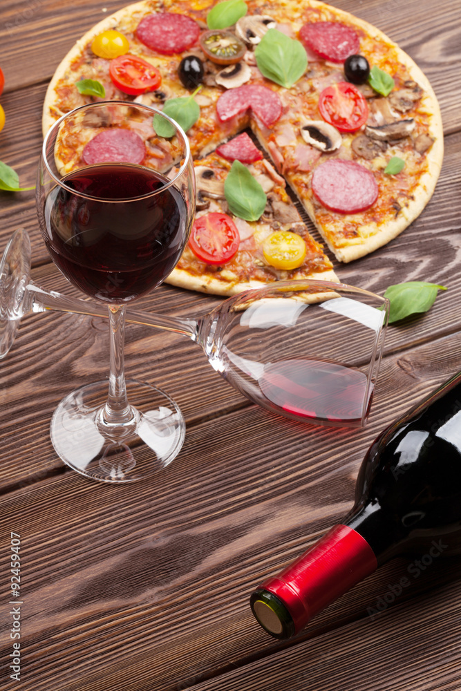 Italian pizza with pepperoni, tomatoes, olives, basil and red wi Italian pizza with pepperoni, tomatoes, olives, basil and red wi