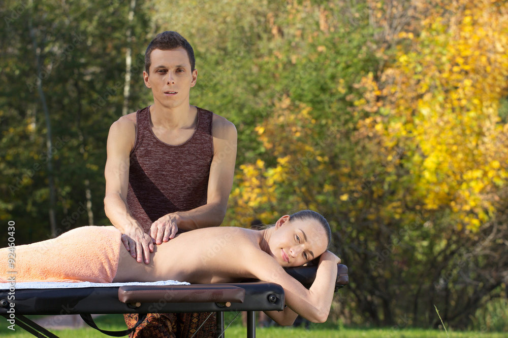 © PaulShlykov - A good-looking man doing a back massage
