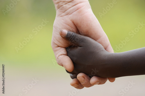 Beautiful Peace Symbol - White Woman Black Child Holding Hands. African Peace Symbol. White woman holds hands with a little native African girl, in Bamako, Mali.