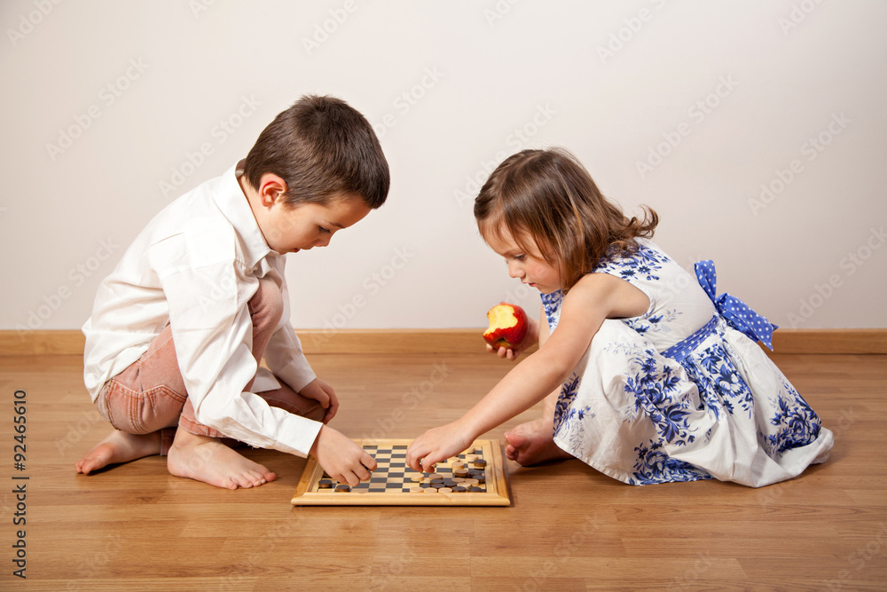 Fototapeta premium Brother and sister playing chess