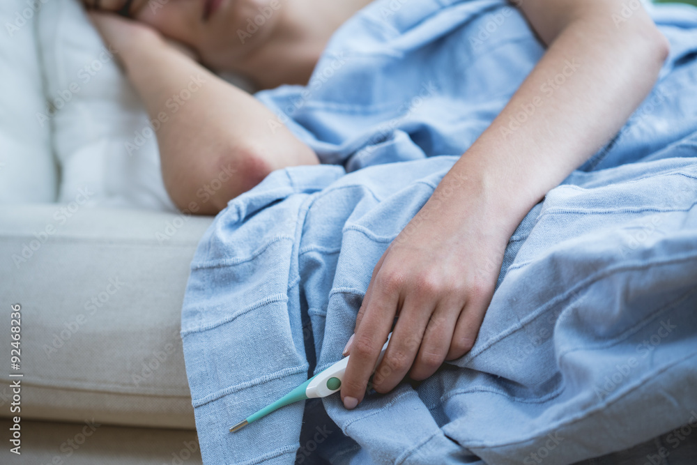 Ill woman holding thermometer