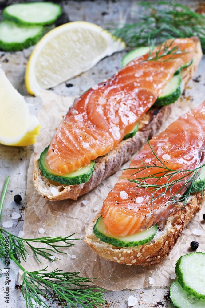 Sandwich with smoked salmon and cucumber on grilled baguette . Selective focus. Sandwich with smoked salmon and cucumber on grilled baguette . Selective focus.