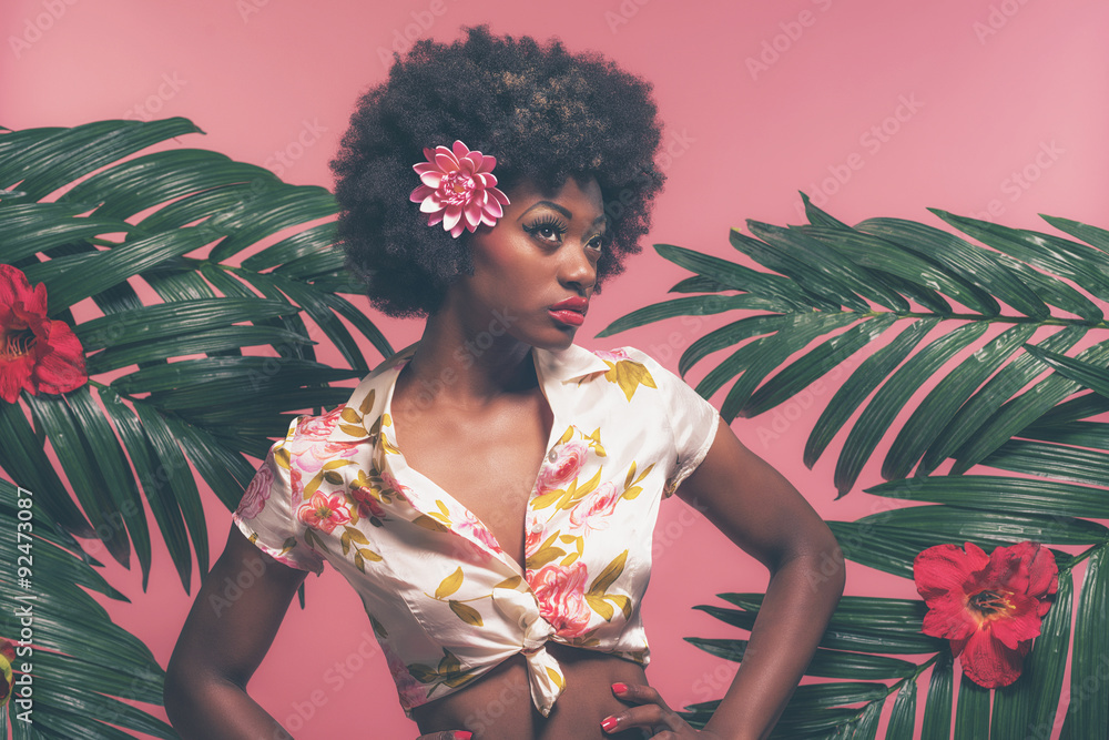 Naklejka premium Zmysłowa afroamerykańska szpilka między liśćmi palmowymi. Przeciw Pink B