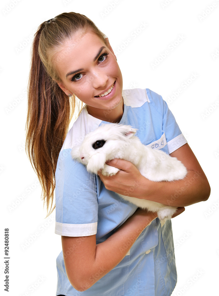 Smiling vet holding up and examining cute brown rabbit at pets' clinic. Smiling vet holding up and examining cute brown rabbit at pets' clinic.