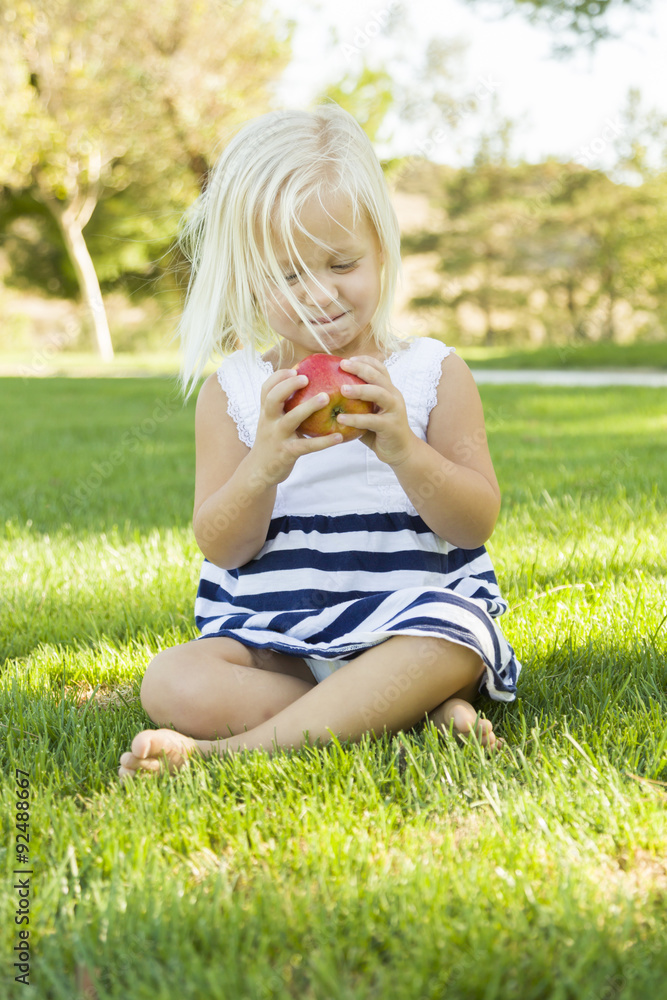 Little Girl Sitting and Eating Apple Outside Little Girl Sitting and Eating Apple Outside