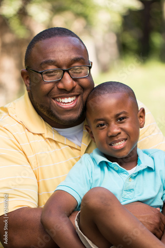 African American father and son hugging and laughing. © pixelheadphoto