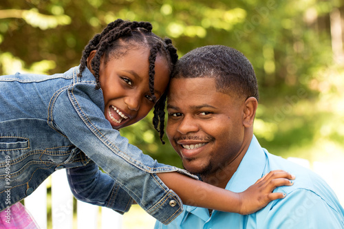 African American daughter hugging her father.