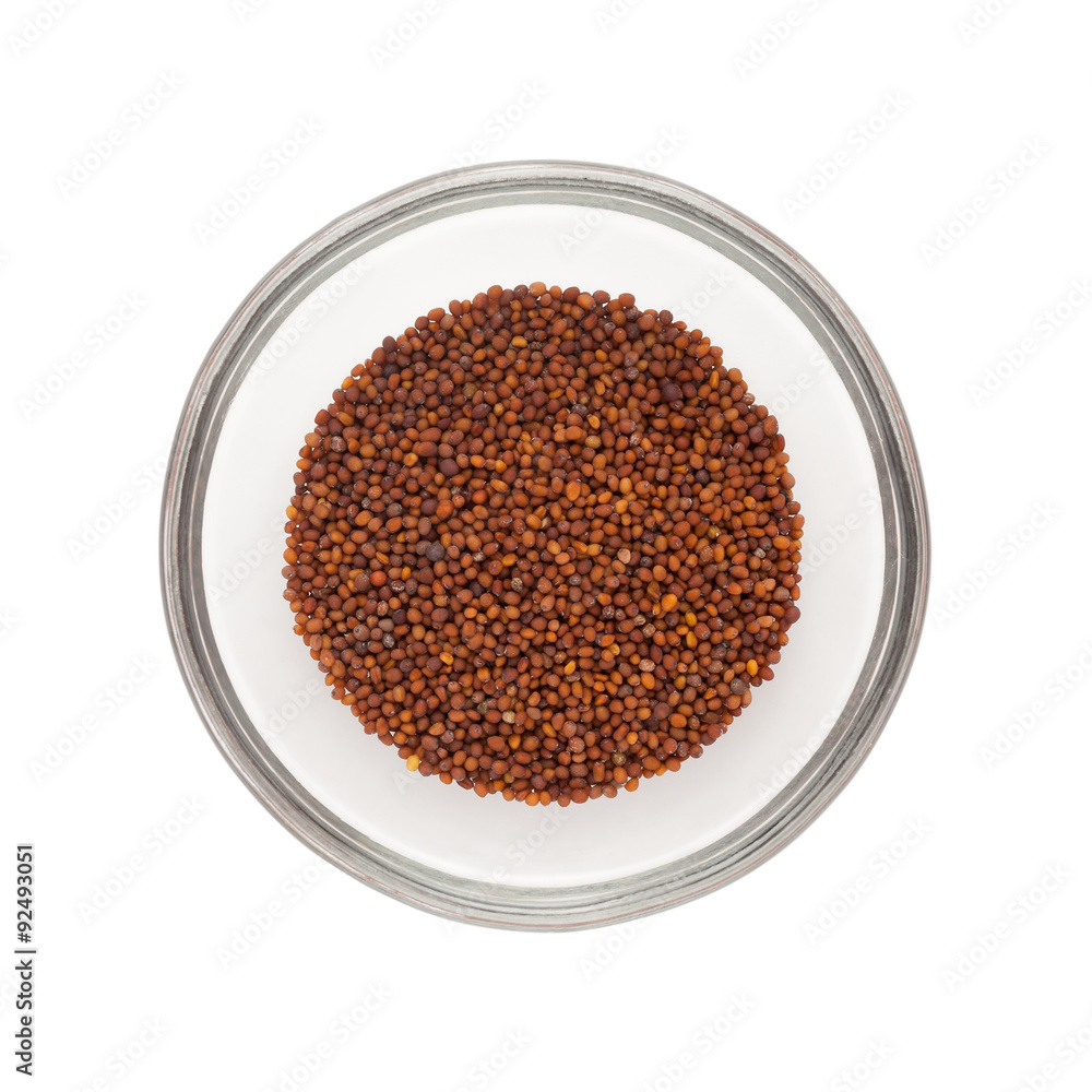 Top view of Organic Small Brown Mustard Seeds (Brassica juncea) half filled in glass bowl isolated on white background. Top view of Organic Small Brown Mustard Seeds (Brassica juncea) half filled in glass bowl isolated on white background.