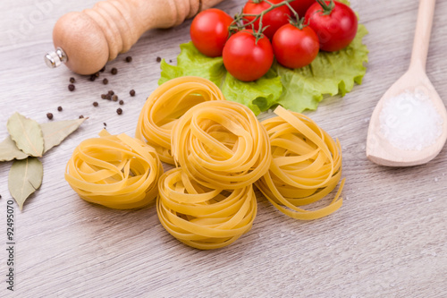 Pasta, tomatoes and pepper on a wooden background