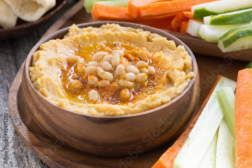 Traditional hummus in bowl with pita bread and vegetables