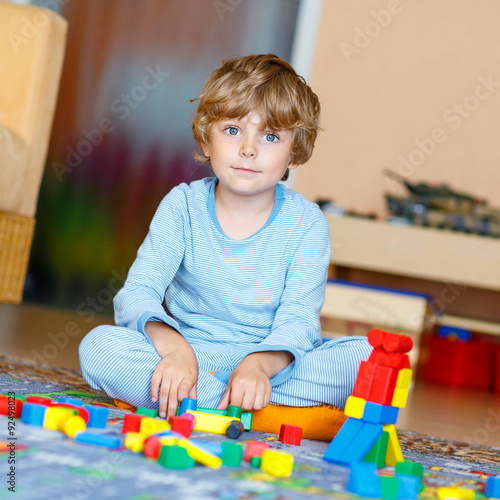 Wallpaper Mural Little blond child playing with colorful wooden blocks indoor Torontodigital.ca