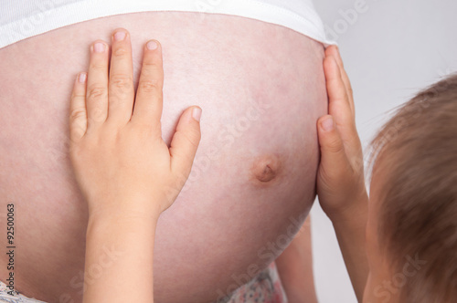 Happy family. Happy child touches the belly of a pregnant mother
