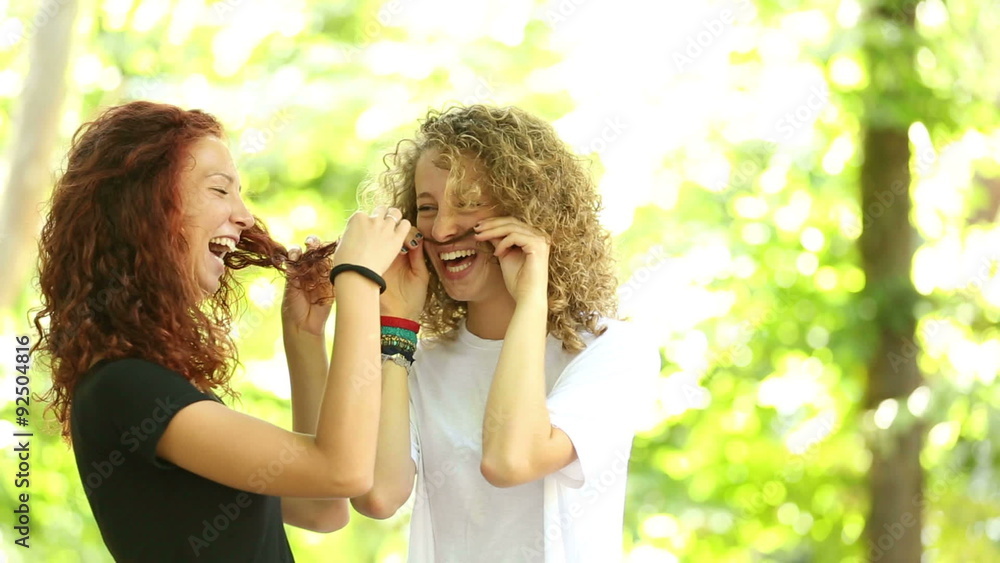 Two girls playing at park and making mustache with their hair
Two girls playing at park and making mustache with their hair