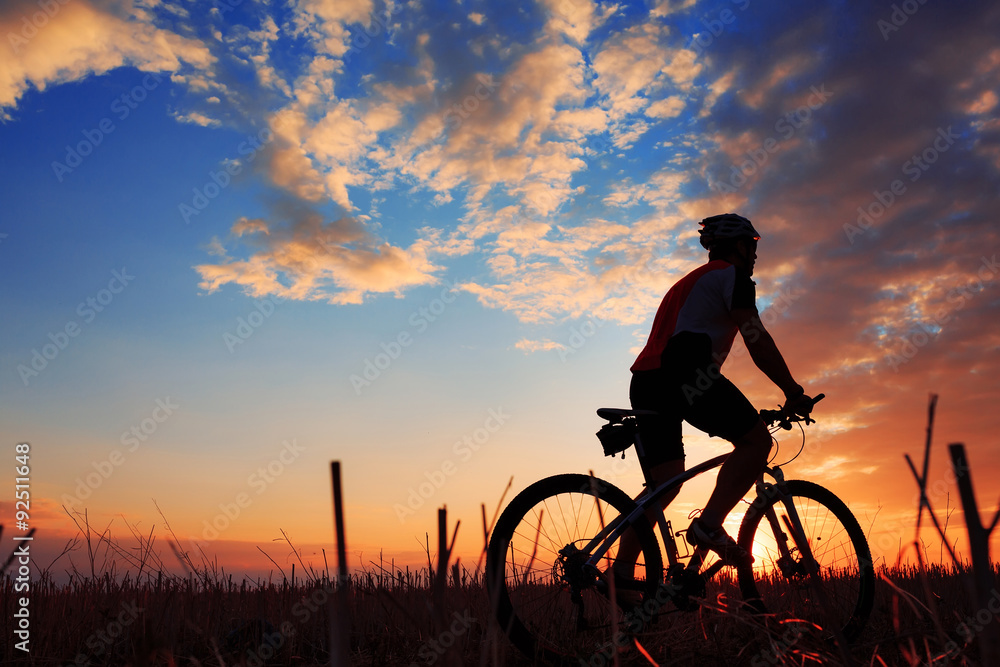 Silhouette of a biker and bicycle on sunset background. Silhouette of a biker and bicycle on sunset background.