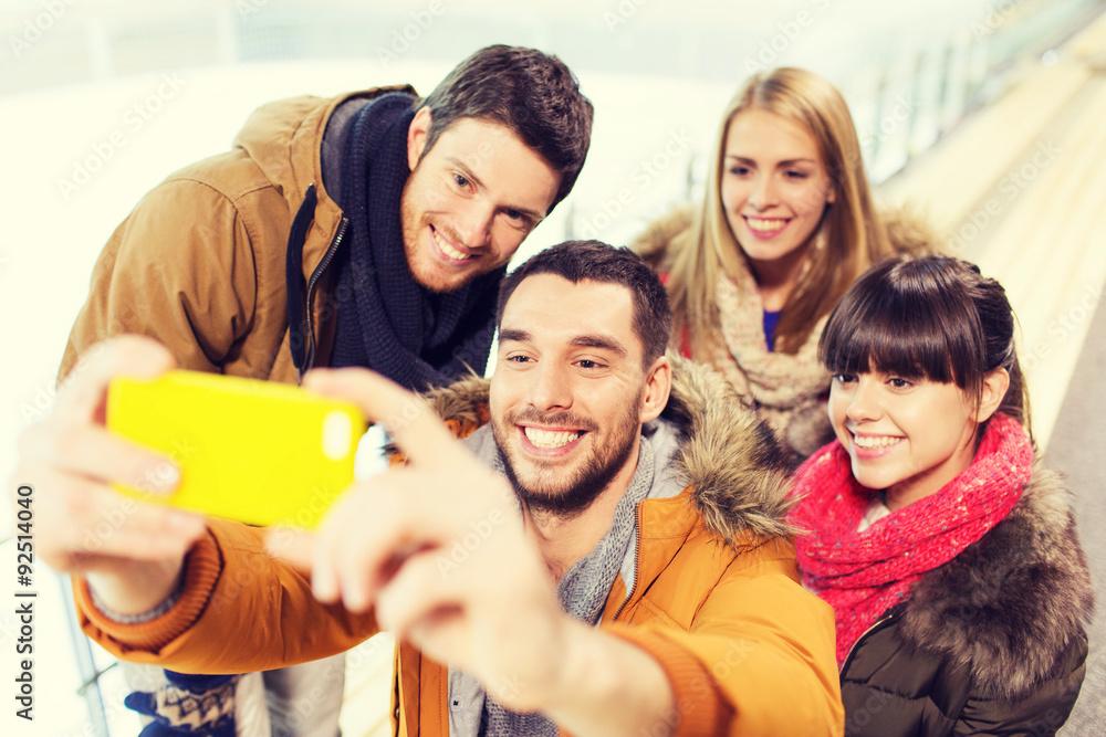 happy friends with smartphone on skating rink happy friends with smartphone on skating rink