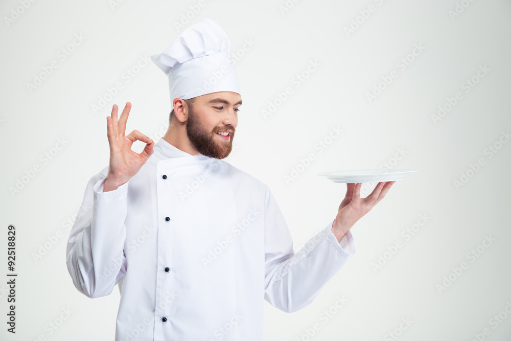 Man chef showing ok sign and empty plat Man chef showing ok sign and empty plat