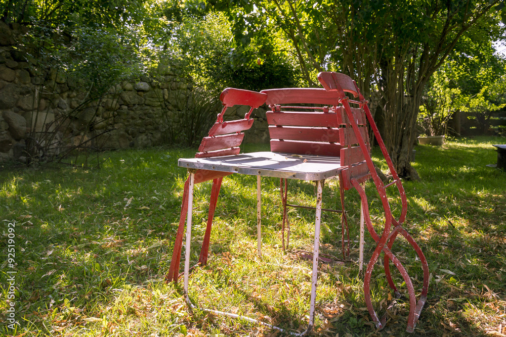 three old, red folding chairs leaning against a table three old, red folding chairs leaning against a table
