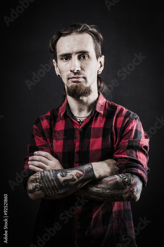 Portrait of a man with naked torso and tattooes