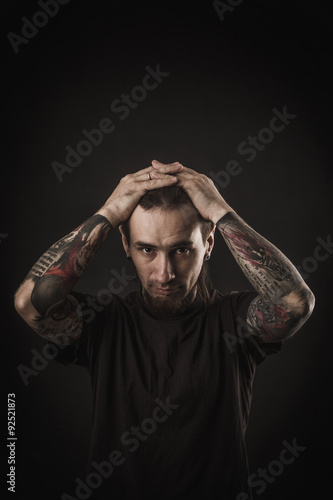 Portrait of a man with naked torso and tattooes